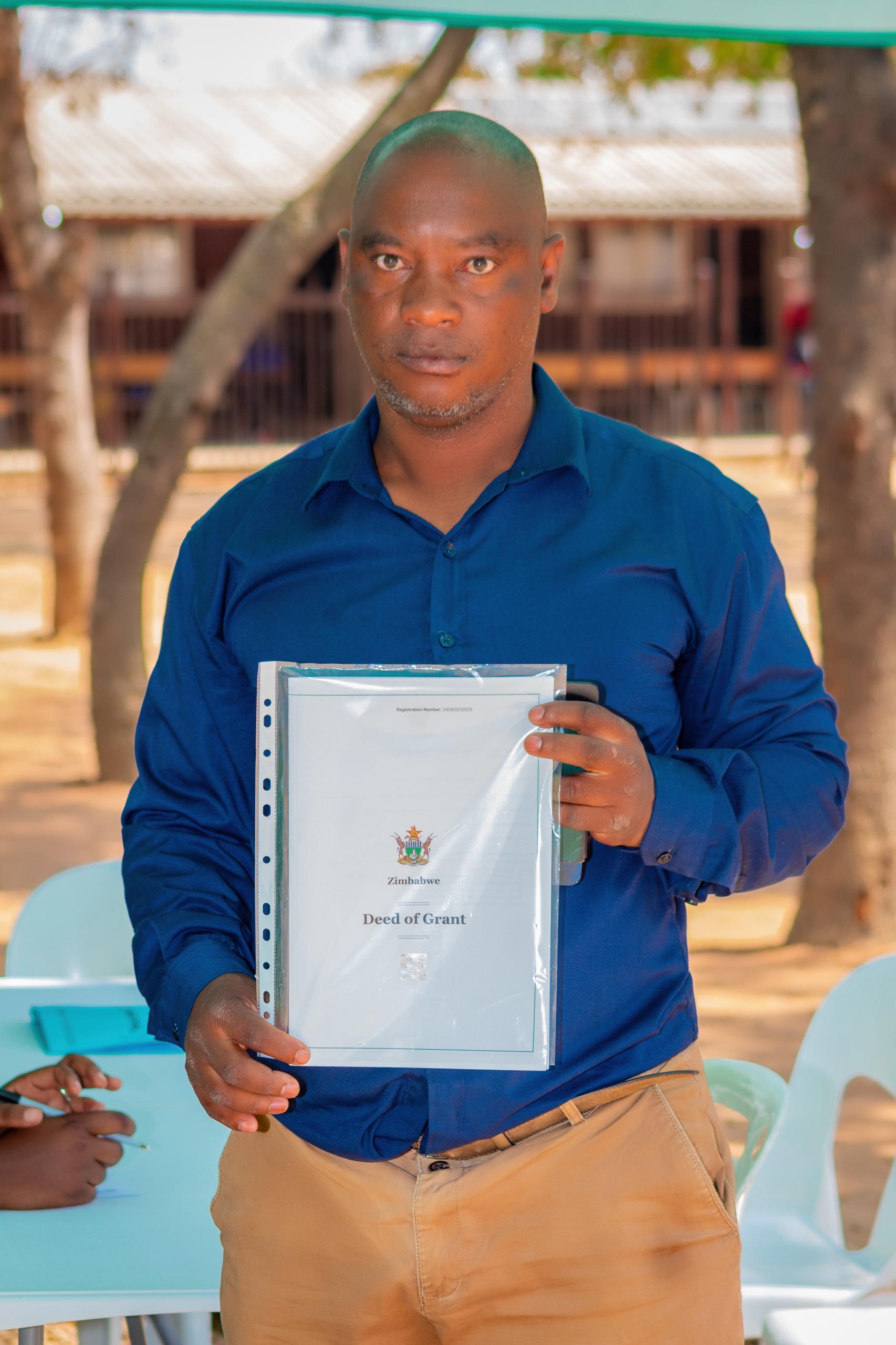Beneficiary receives a Deed of Grant during the Epworth handover.